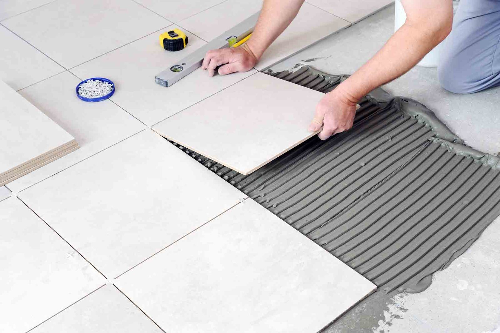 homeguide-worker-installing-ceramic-tile-flooring